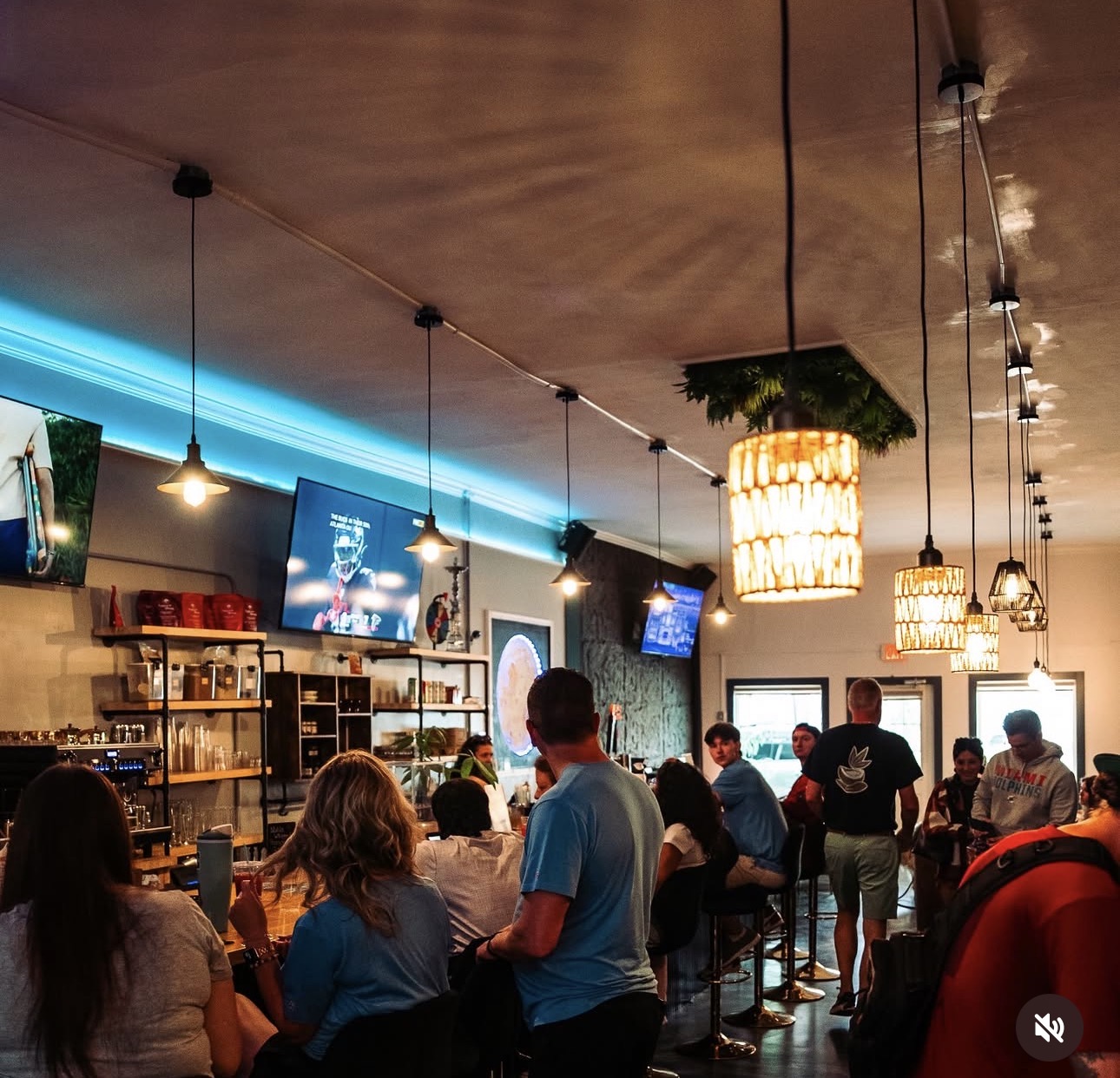 Inside Noble Brew — guests at the bar with warm pendant lights and neon glow